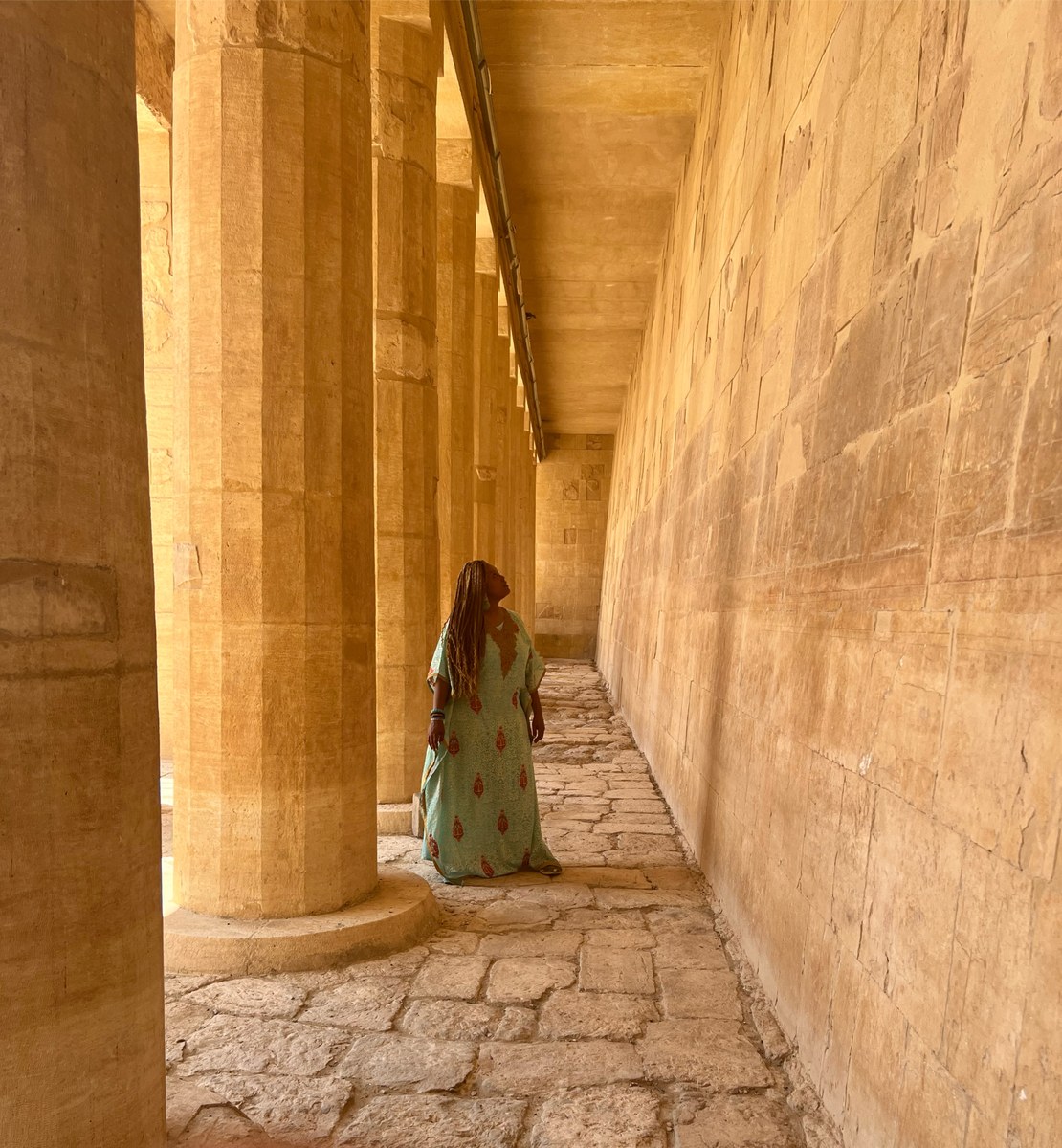 Sheharazaad walking through an ancient Egyptian temple corridor