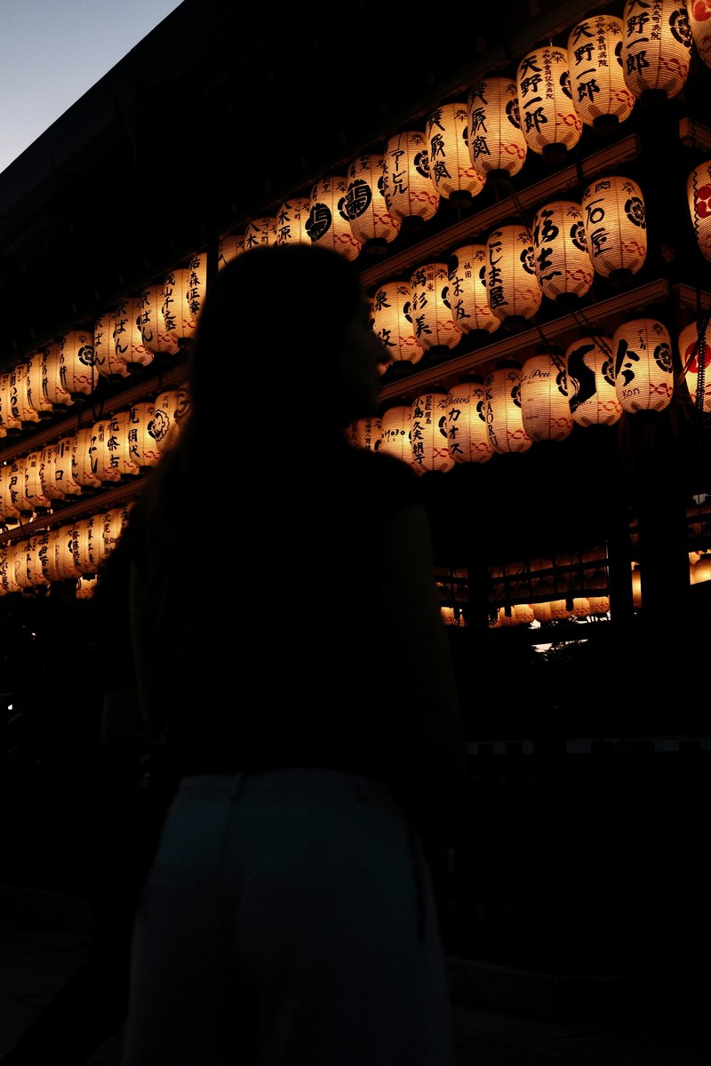Silhouette before glowing Japanese lanterns at dusk